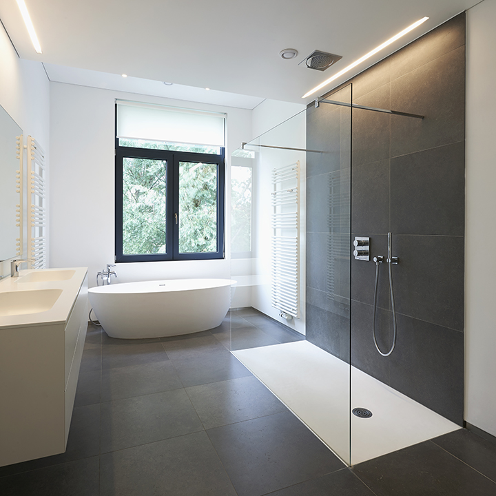 Bathtub in corian, Faucet and shower in tiled bathroom with windows towards garden